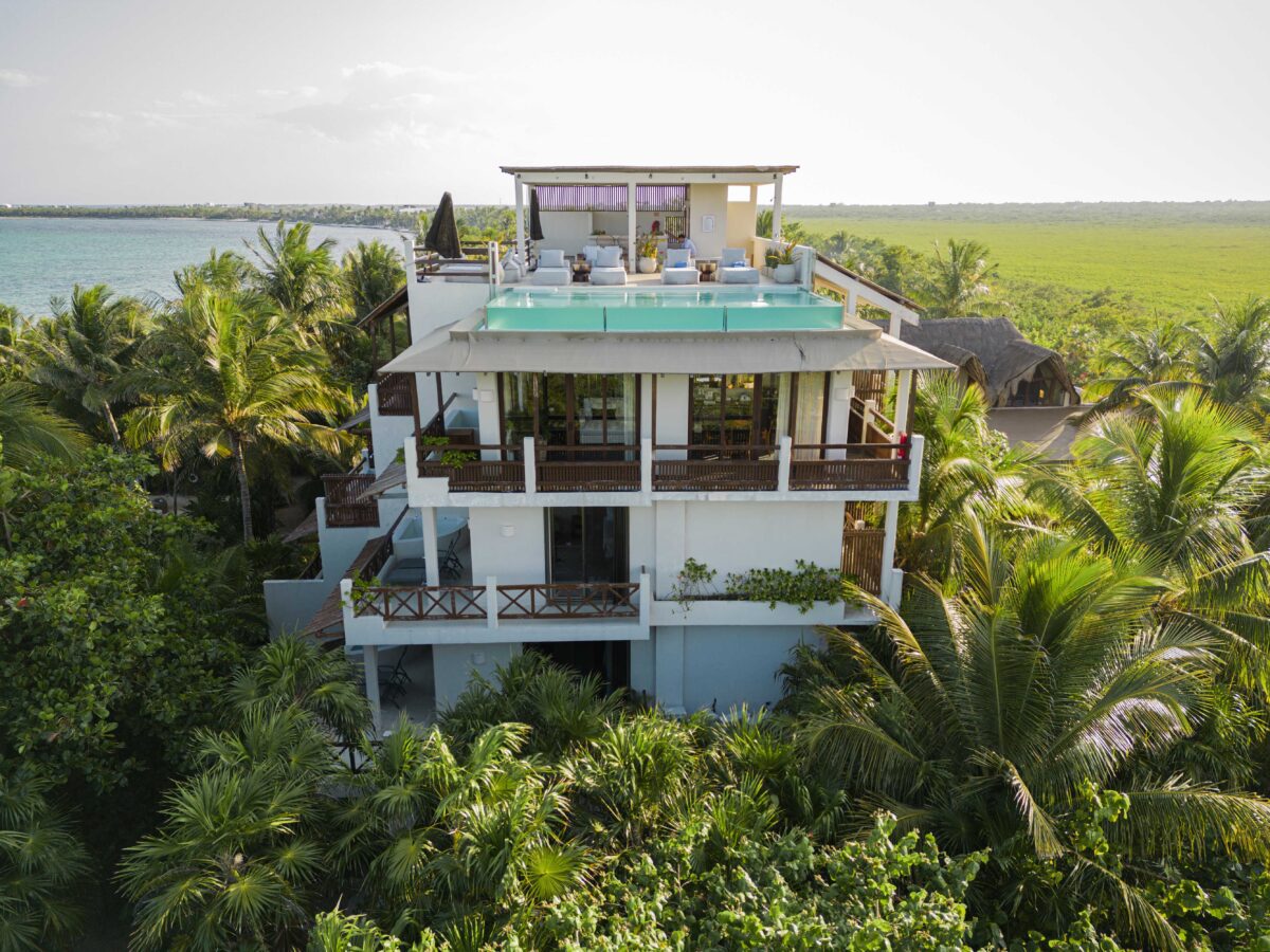 Jashita Hotel Tulum aerial view with rooftop pool surrounded by lush greenery and ocean backdrop. Ideal Tulum wedding venue.