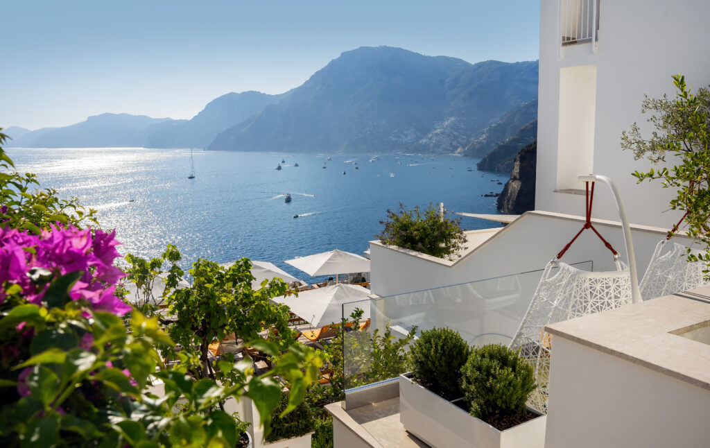 Stunning Amalfi Coast view from Casa Angelina, with white architecture, blue sea, and distant mountains.