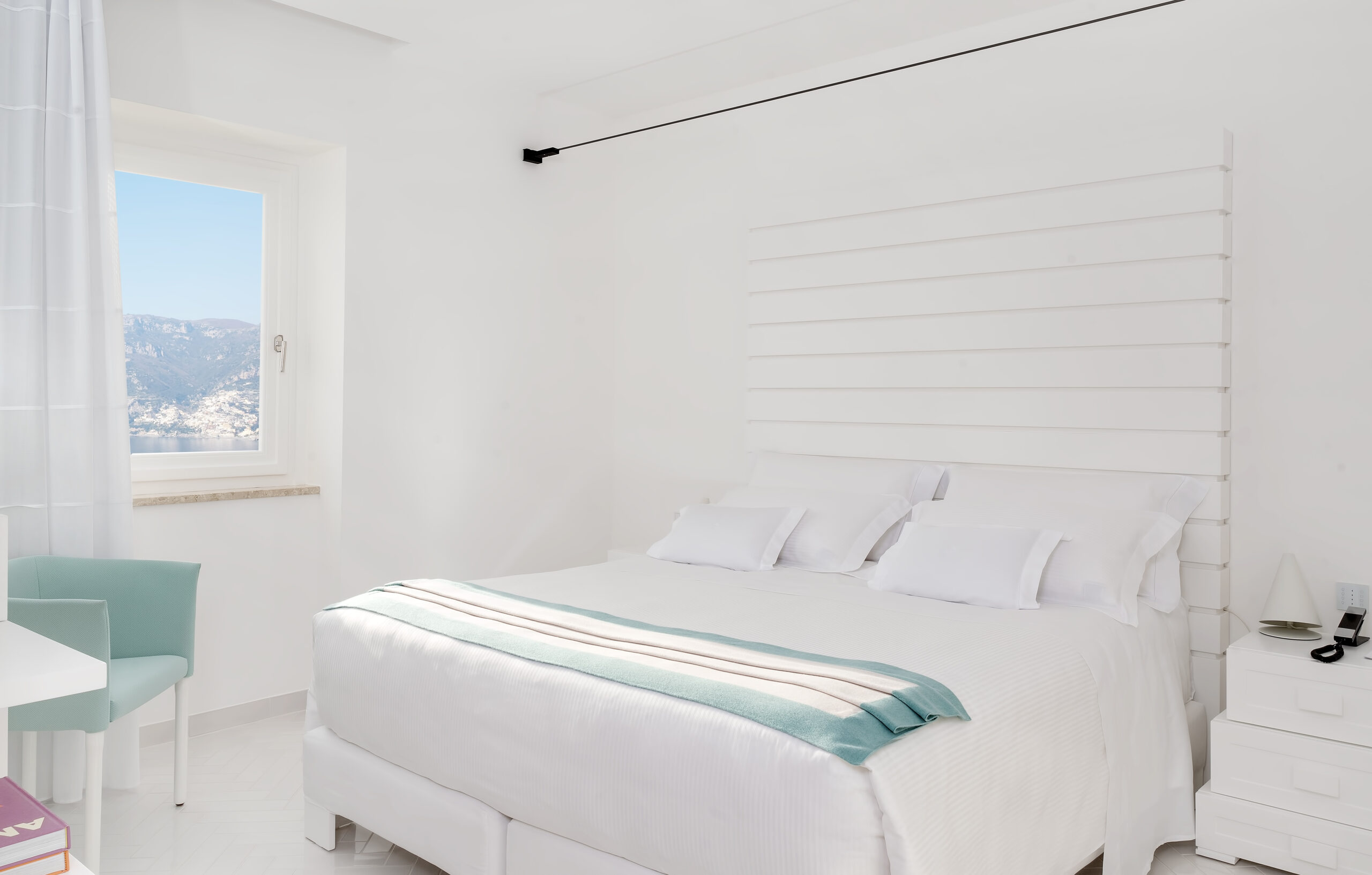 Elegant white bedroom at Casa Angelina with Amalfi Coast view.