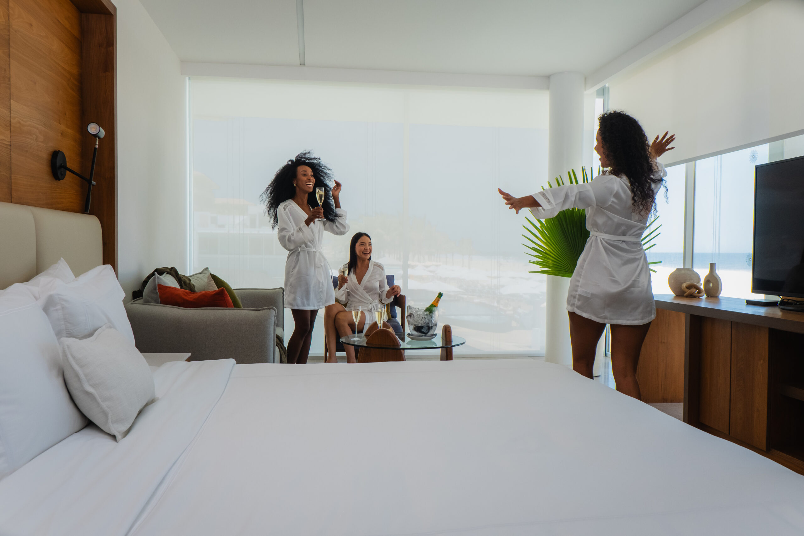 Friends celebrating with champagne in a luxurious suite at the Viceroy Los Cabos, a Mexico beach resort.
