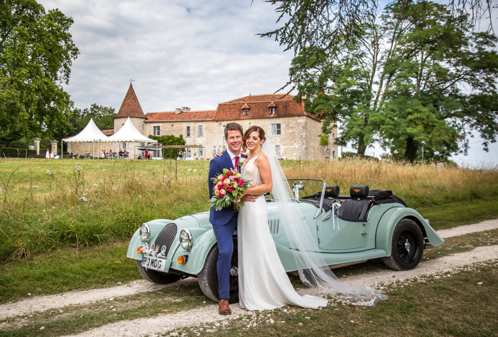 wedding couple in front of blue vintage convertible car