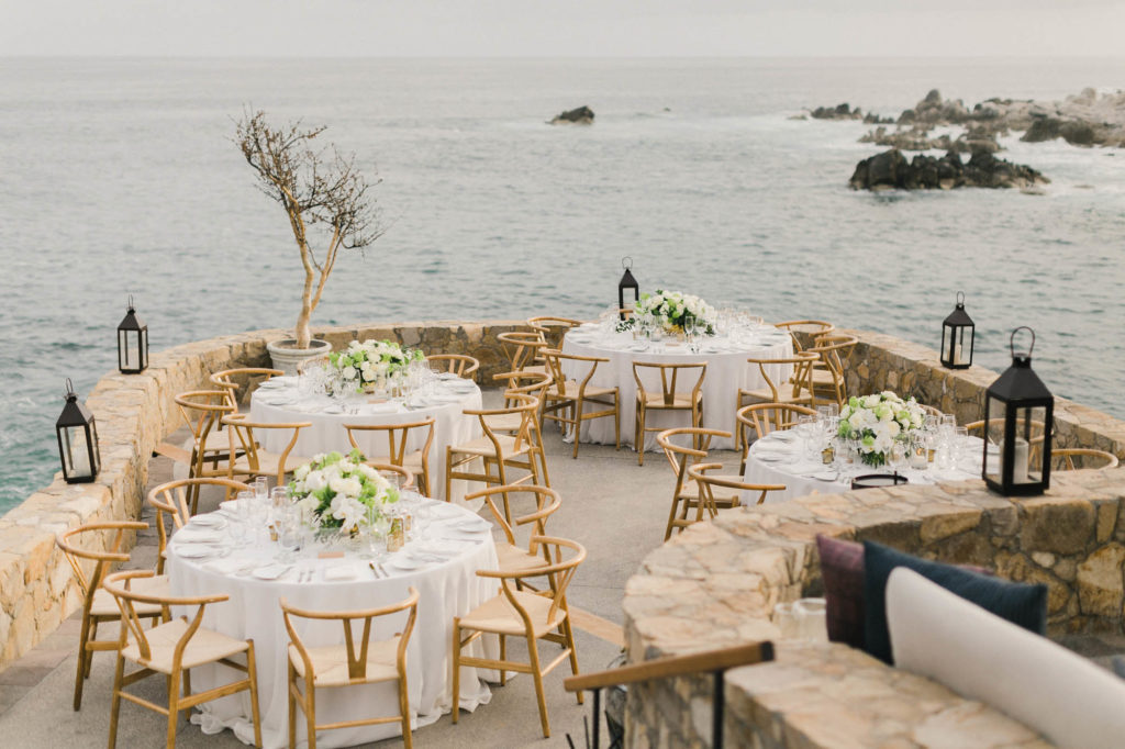Four wedding round tables on a terrace overlooking the sea