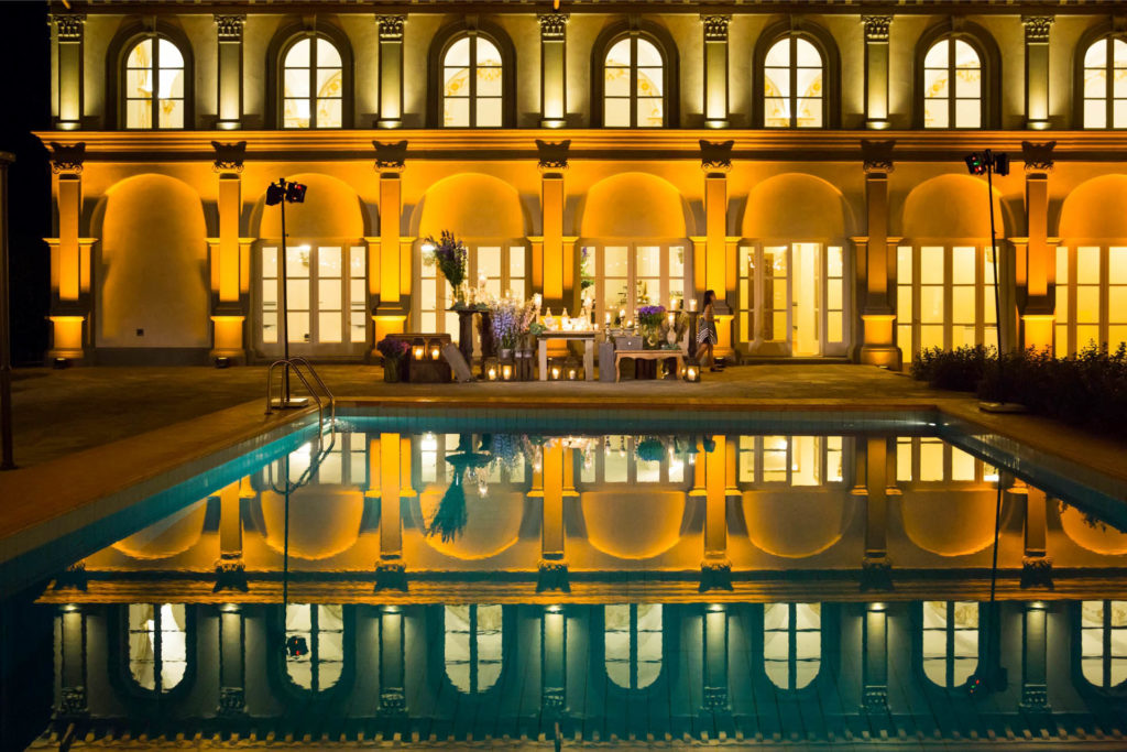 Pool & building at night with small banquet table in the distance