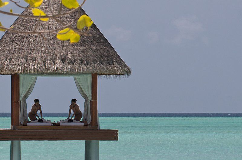 couples massage in an elevated thai hut over the sea