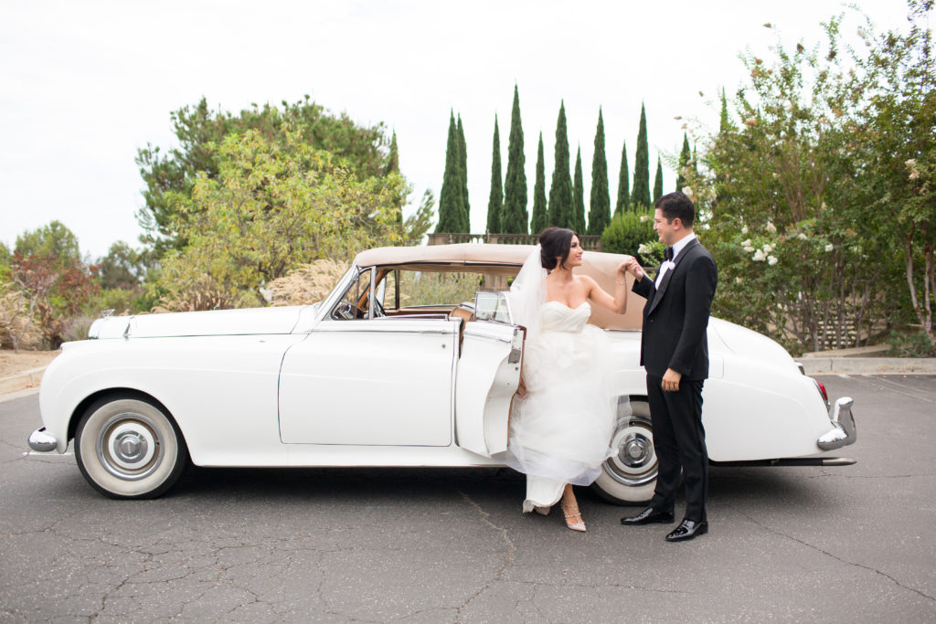 Bride getting out of rolls royce with groom