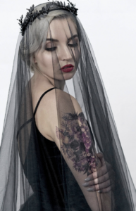 bride wearing black headpiece, black sleeveless dress & balck lace veil with red lipstick