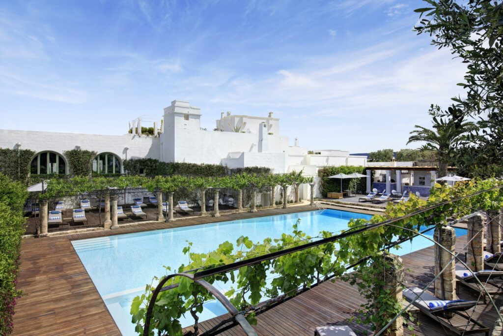 Long shot of pool & white buildings of hotel in puglia