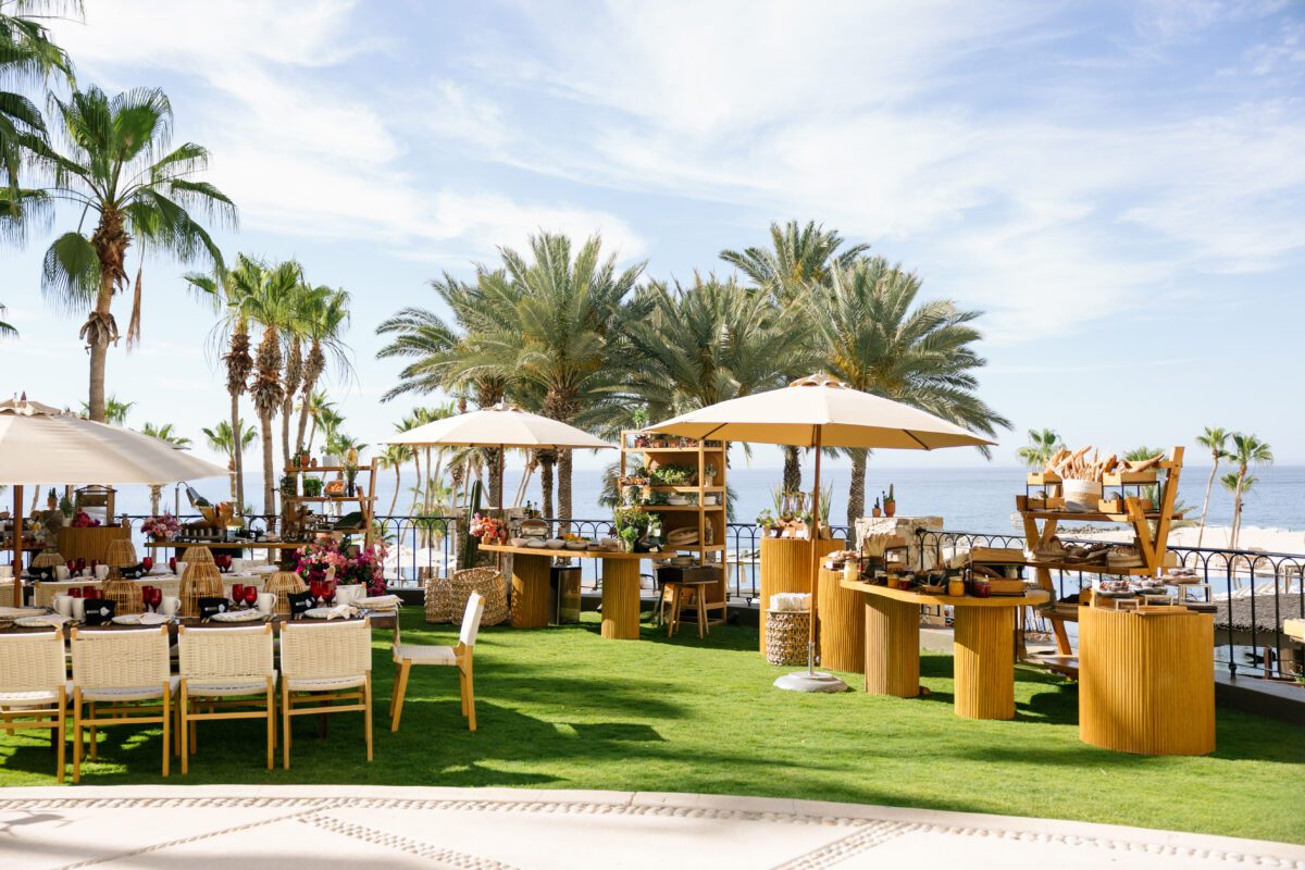 Los Cabos destination wedding setup at Hilton Los Cabos with tables, chairs, and palm trees.