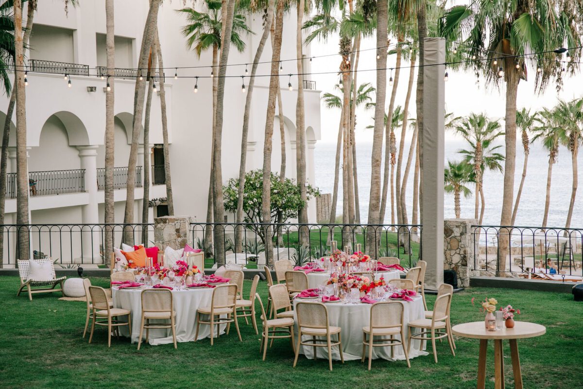 Los Cabos destination wedding reception at Hilton Los Cabos with round tables and palm trees.