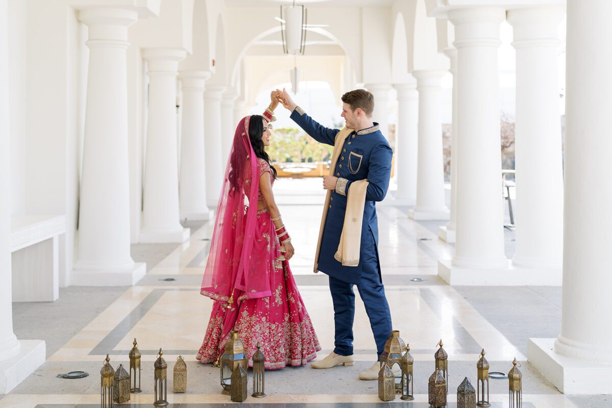 Los Cabos Destination Wedding at Hilton. Bride and groom under chandelier.