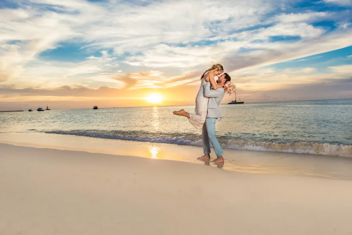 Couple celebrating their Hilton Aruba Destination Wedding on a beach at sunset
