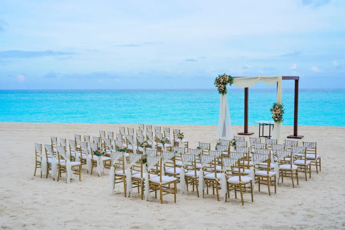 Beachfront destination wedding ceremony setup at Kempinski Hotel Cancún resort.