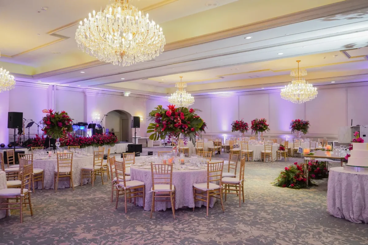 Elegant ballroom setup at a Destination Wedding Resort, Kempinski Hotel Cancún, with floral centerpieces and chandeliers.