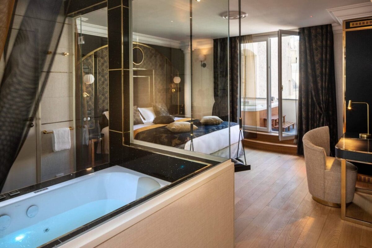 Luxurious Paris hotel suite with jacuzzi tub, bedroom, and private balcony. Perfect for a romantic honeymoon getaway.
