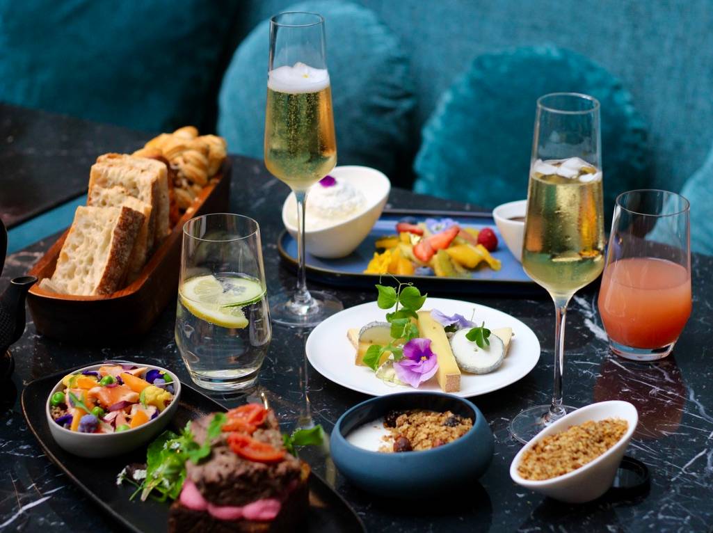 Luxurious Parisian breakfast spread with champagne, pastries, and cheese. Perfect for a romantic honeymoon in Paris.