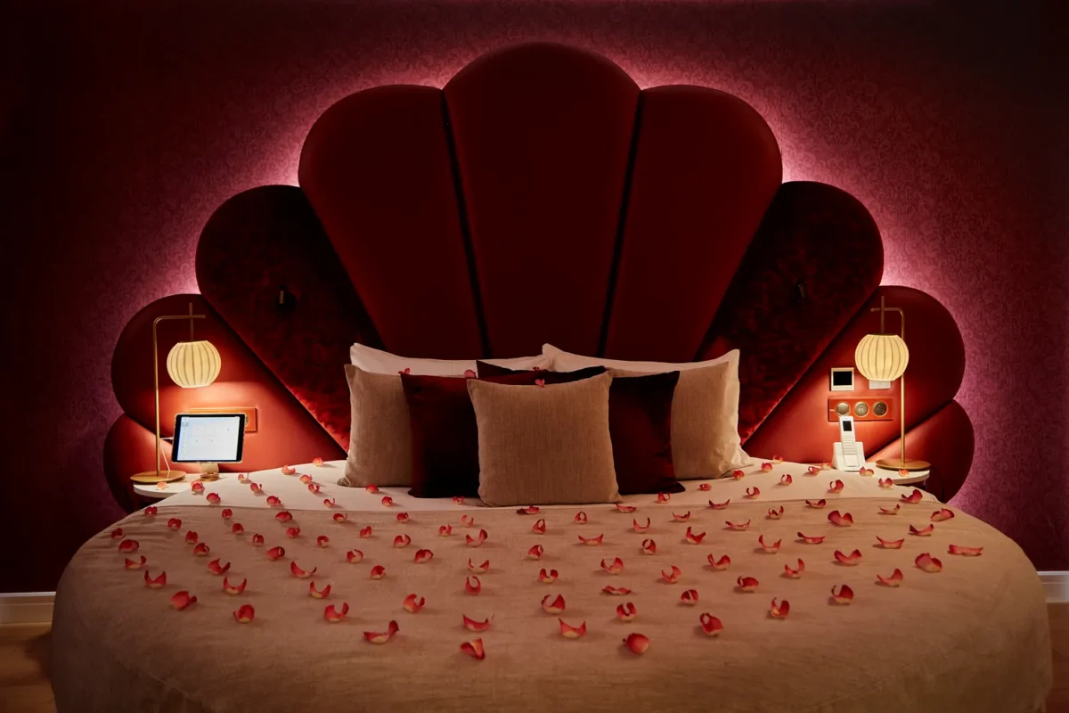 Romantic Paris hotel room with round bed, rose petals, and elegant headboard. Perfect for a honeymoon.