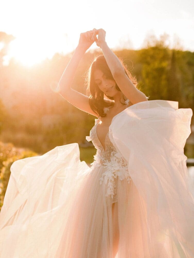 Bride in flowing wedding gown at sunset for destination wedding