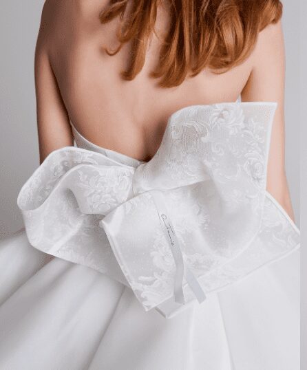 Wedding dress with large lace bow on woman's back