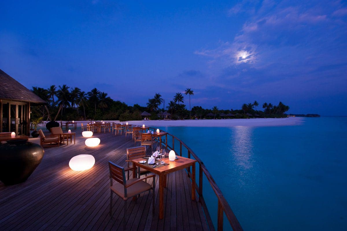 Moonlit waterfront dining at a luxury resort beach
