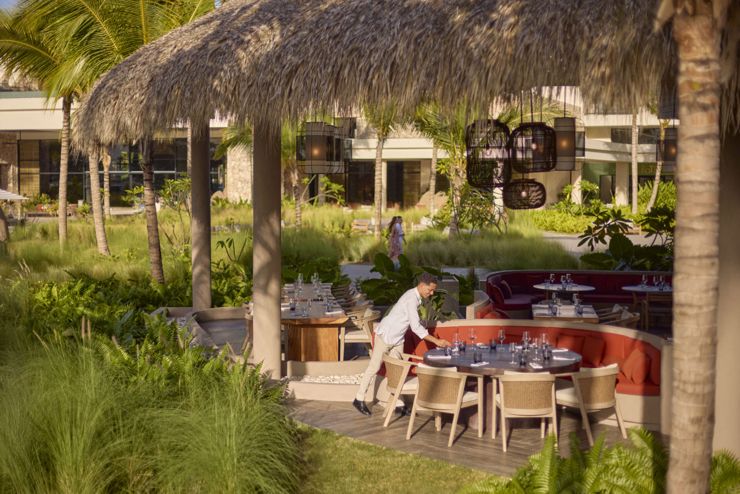 Outdoor dining at Zemi Miches All-Inclusive Resort under thatched roof.