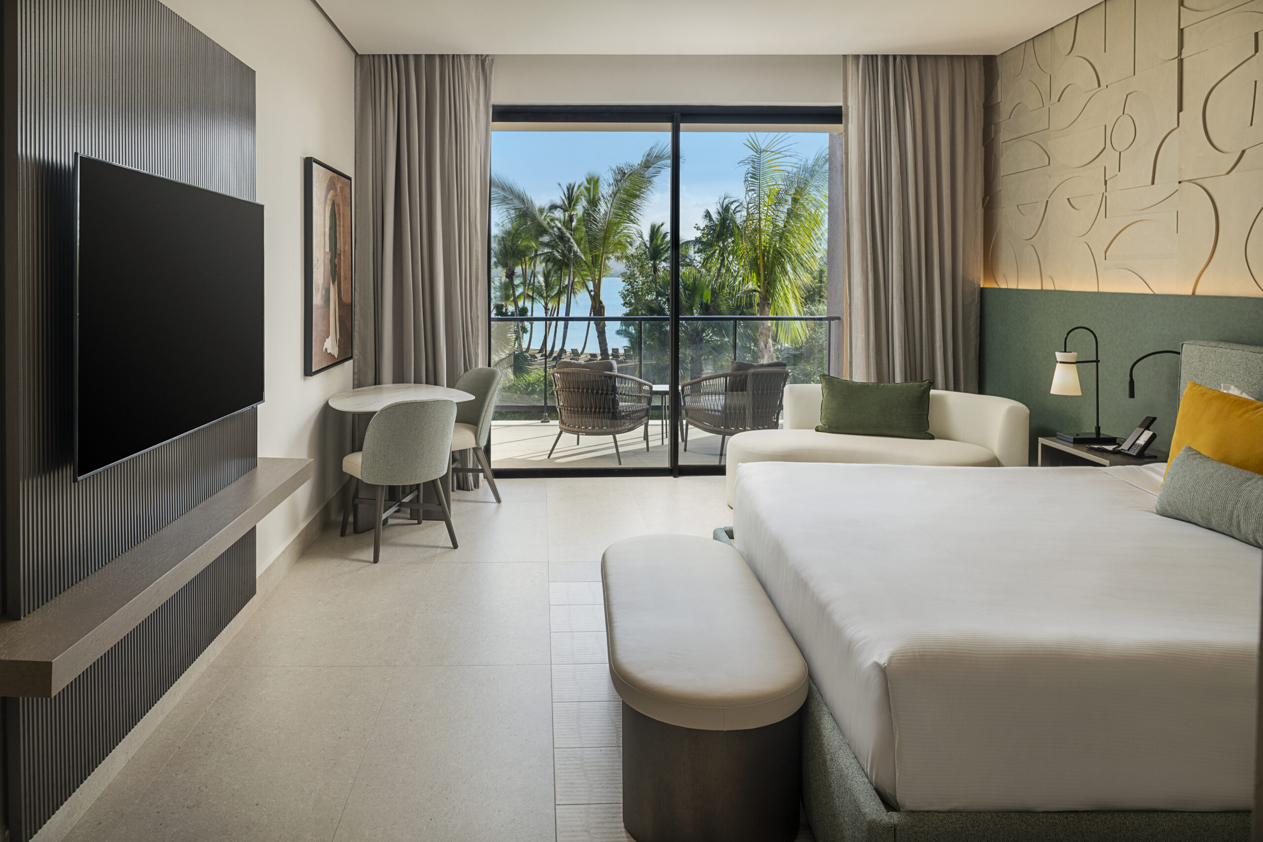 Zemi Miches resort room with balcony view of palm trees and ocean