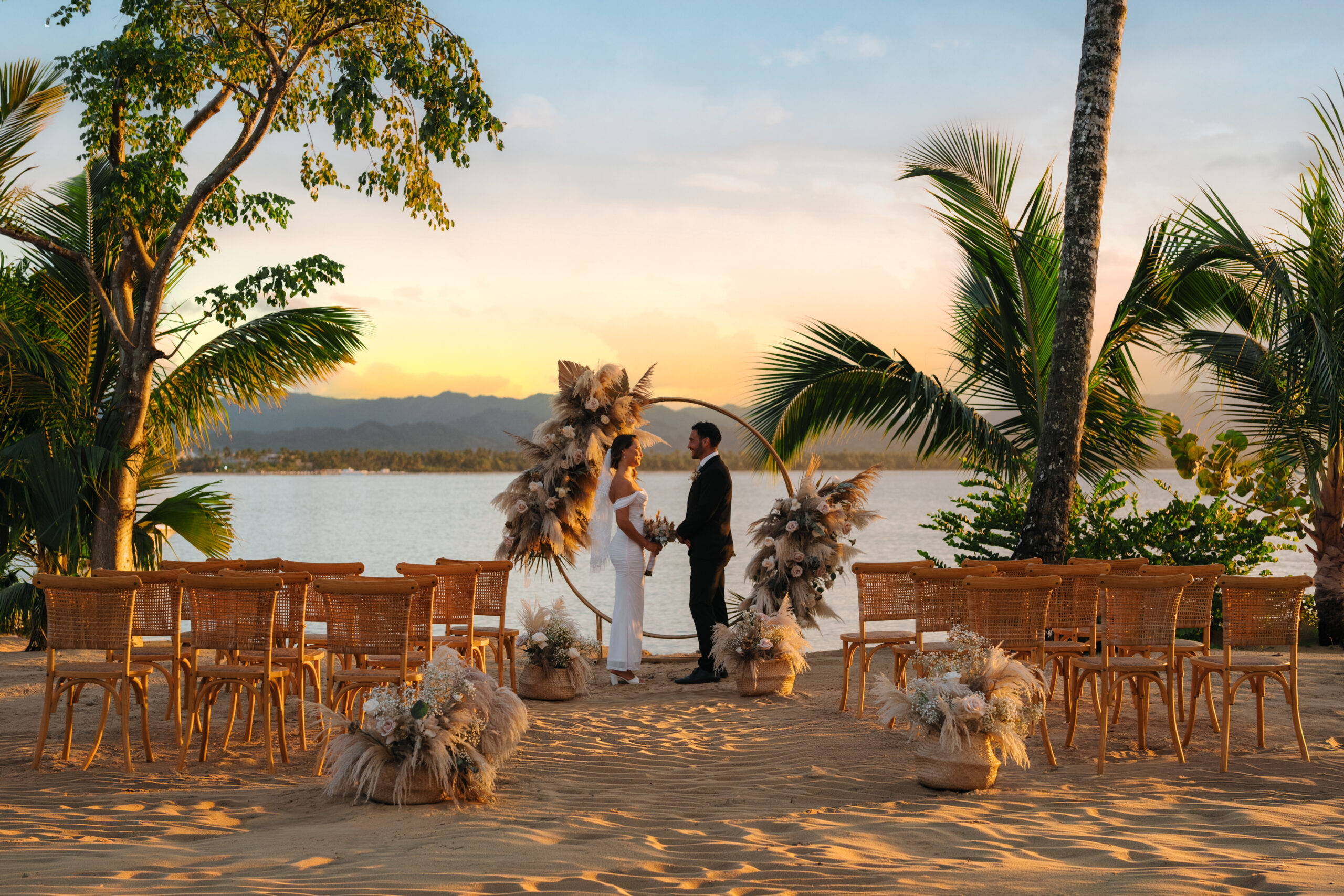 Zemi Miches wedding ceremony on beach at sunset with palm trees and ocean view.