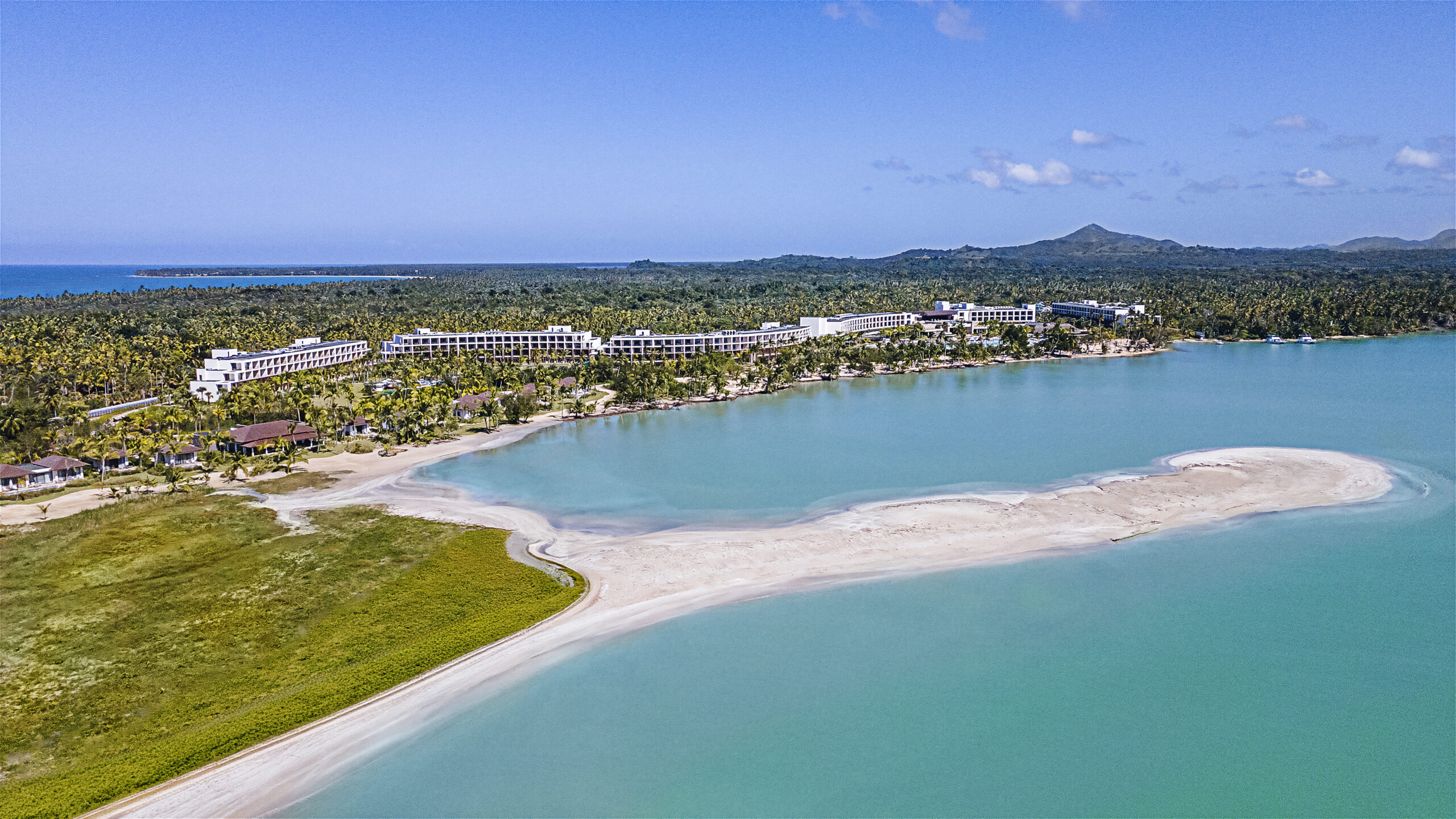 Aerial view of Zemi Miches All-Inclusive Resort, Dominican Republic, with turquoise waters and beachfront buildings.