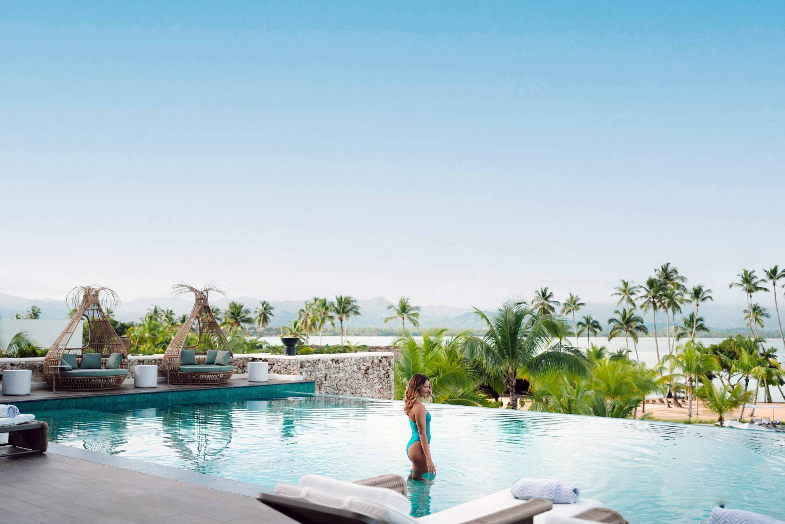 Woman in turquoise swimsuit in infinity pool at Zemi Miches All-Inclusive Resort