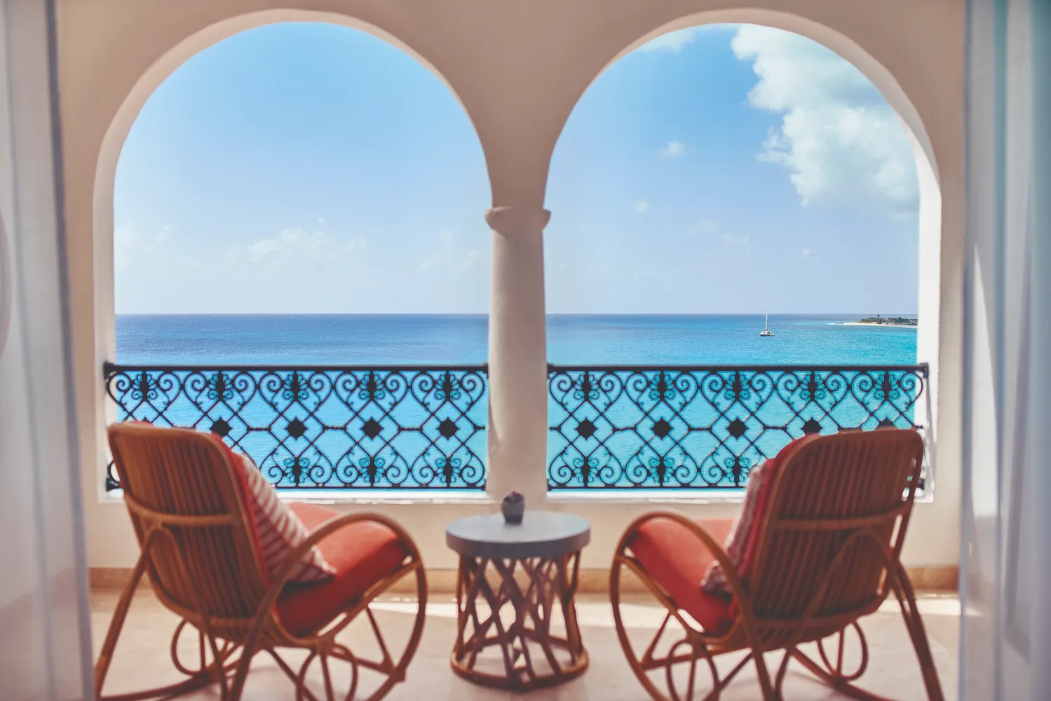 Oceanfront balcony at La Samanna, a Belmond Hotel, St. Martin. Two rocking chairs face the Caribbean Sea, ideal for a destination wedding.