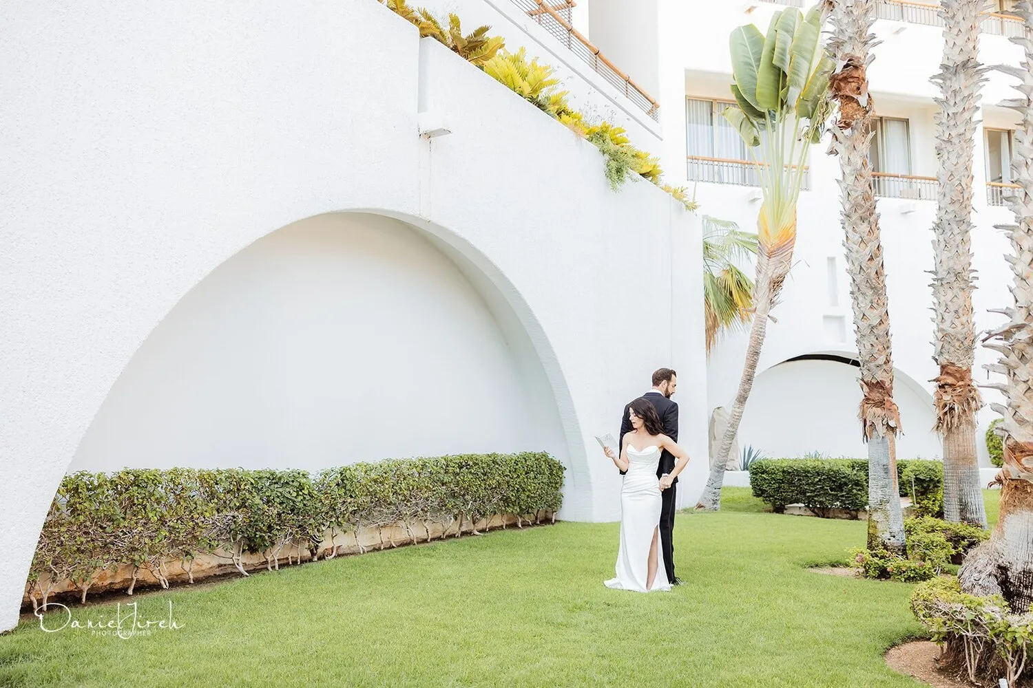 Bride and groom at a Los Cabos wedding, exchanging vows in a beautiful courtyard.