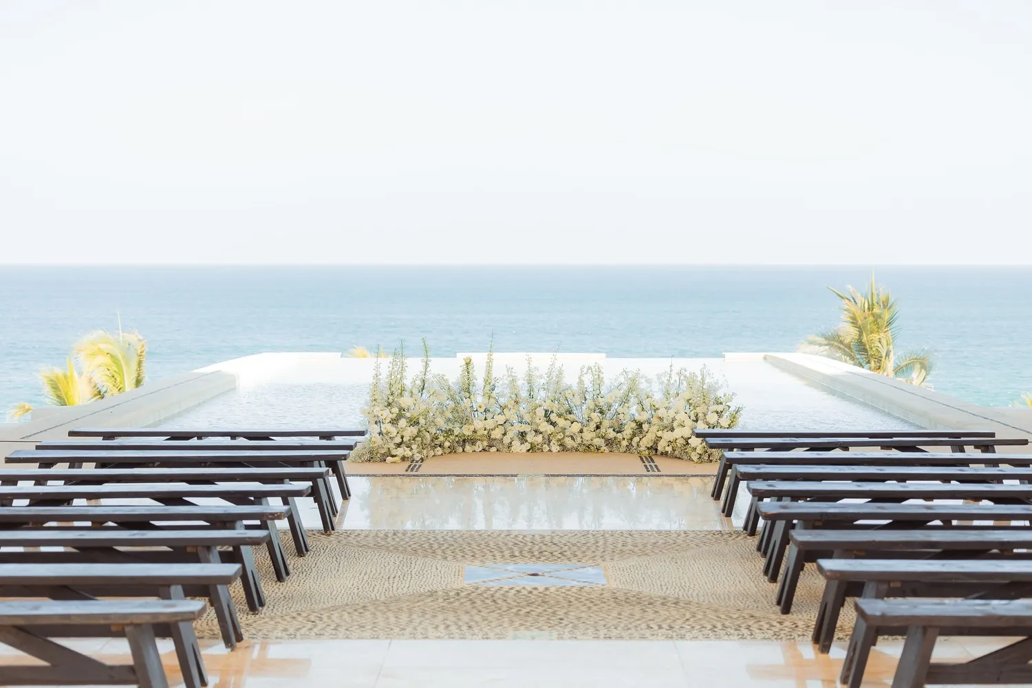 Elegant outdoor wedding ceremony setup at Marquis Los Cabos overlooking the ocean.
