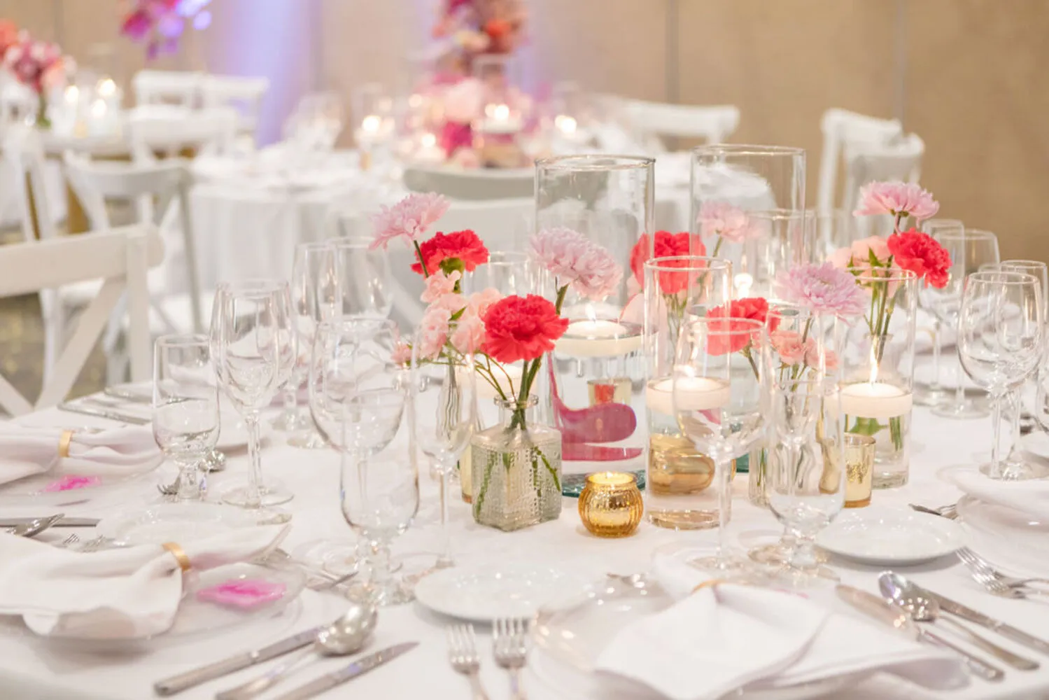 Elegant wedding table setting with pink carnations and candles at a Los Cabos destination wedding.