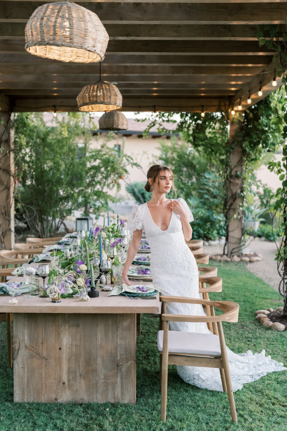 Bride in a lace wedding dress at a styled shoot reception table