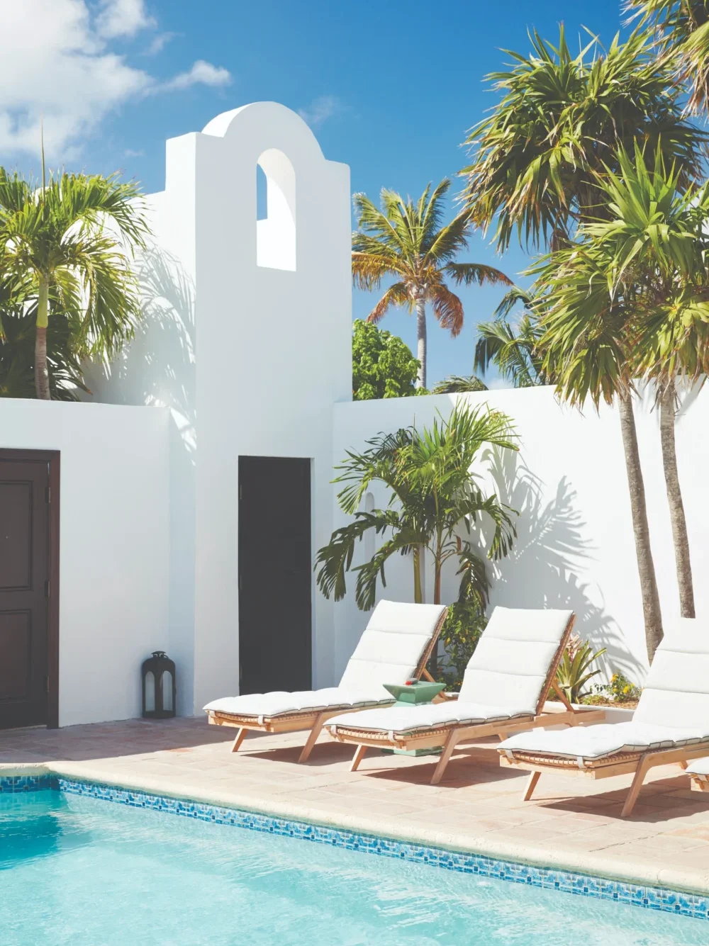 Luxury resort pool with lounge chairs and white building. Relaxing vacation getaway.