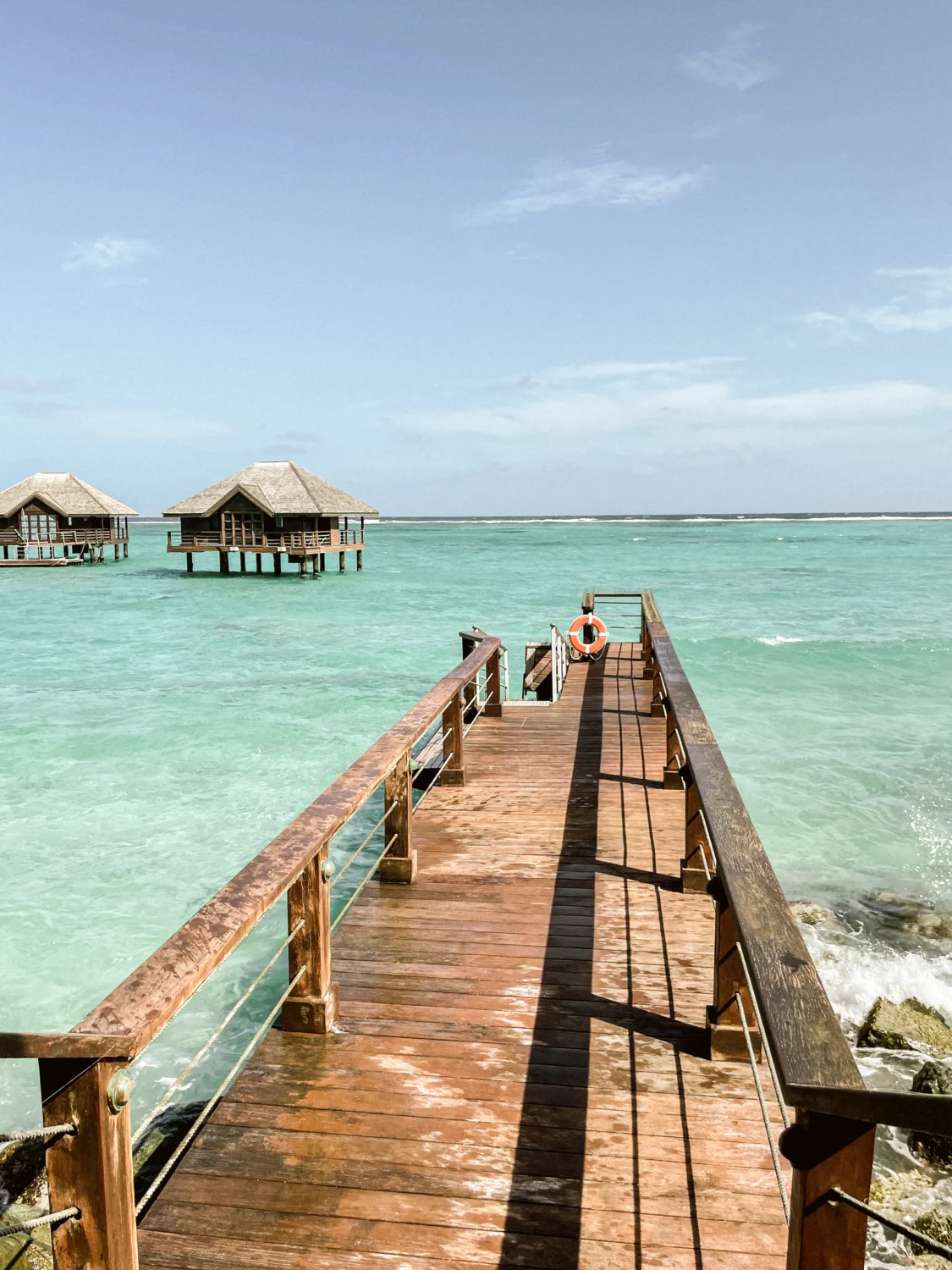 Wooden walkway to overwater bungalows, turquoise ocean