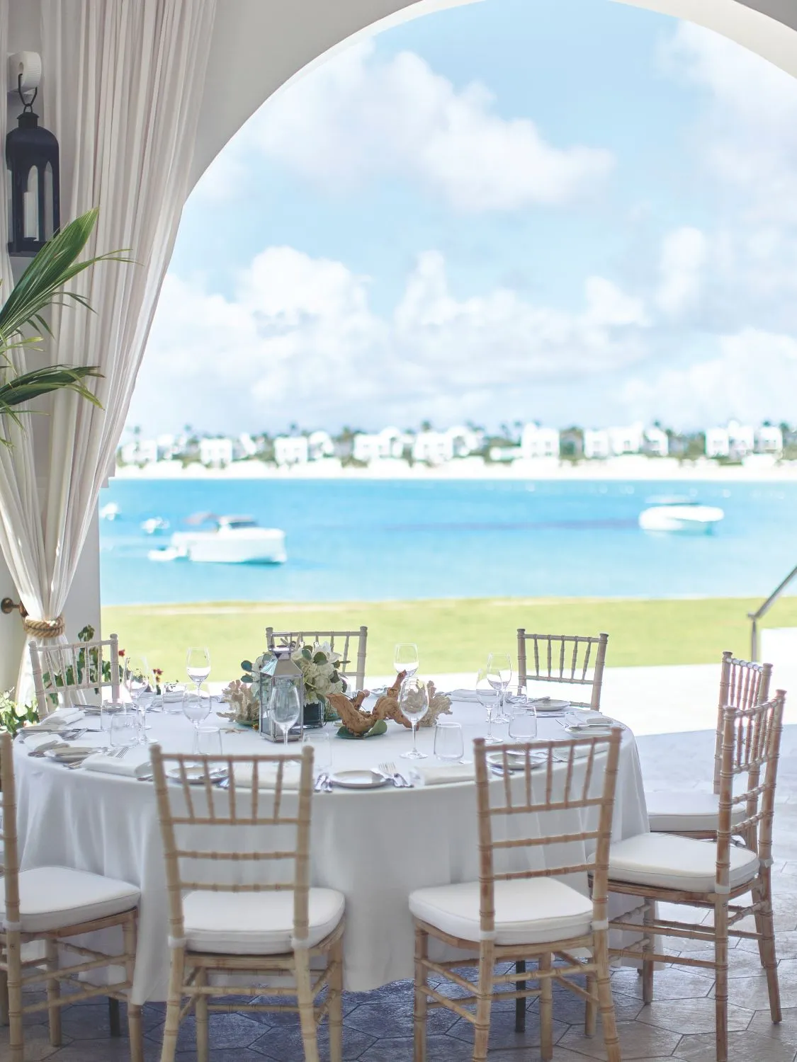 Elegant outdoor dining table overlooking a calm ocean; perfect for a partnership celebration.