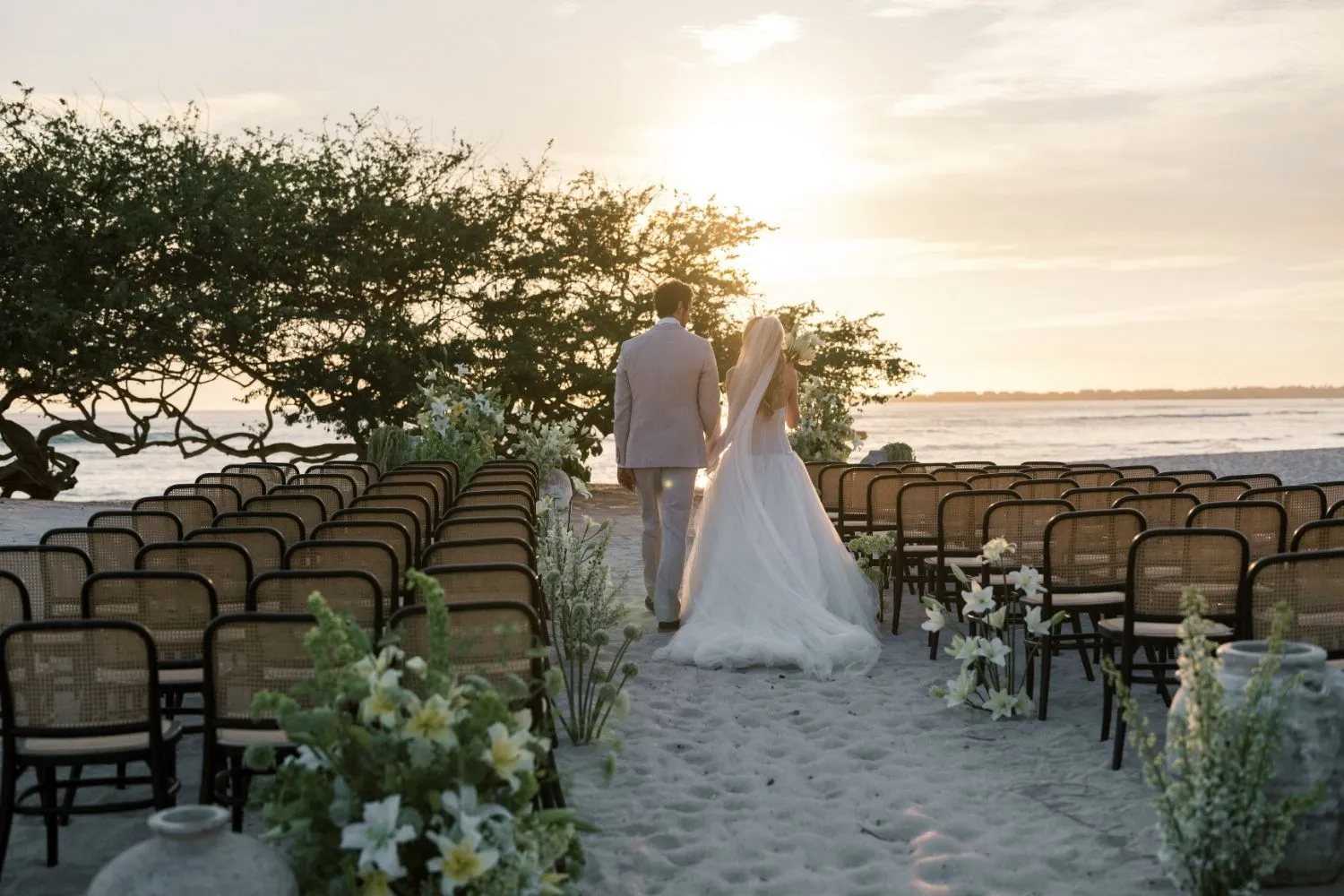 Bride and groom walking away down the aisle after a beach wedding ceremony. Styled shoot.