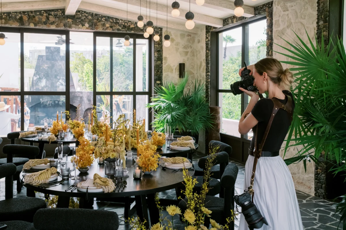 Photographer capturing luxury destination wedding table setting with yellow floral arrangements