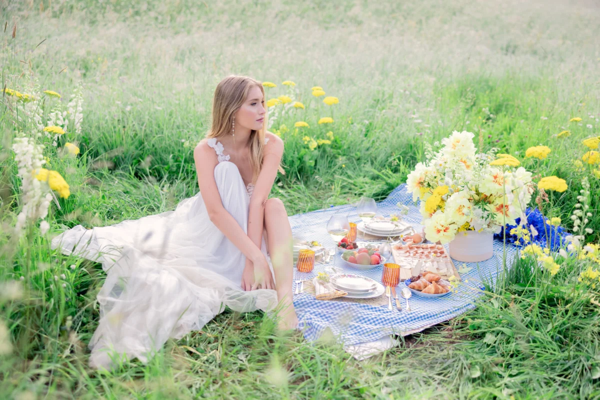 Woman in white dress at a luxury picnic, perfect for luxury destination wedding planning.