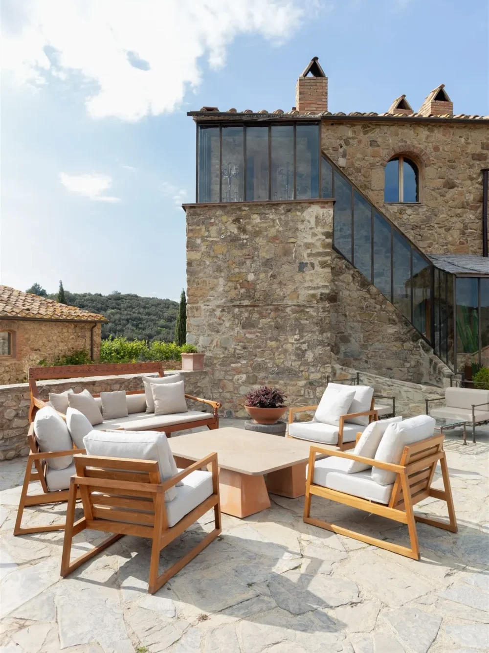 Outdoor patio furniture set on stone patio next to a rustic stone building.