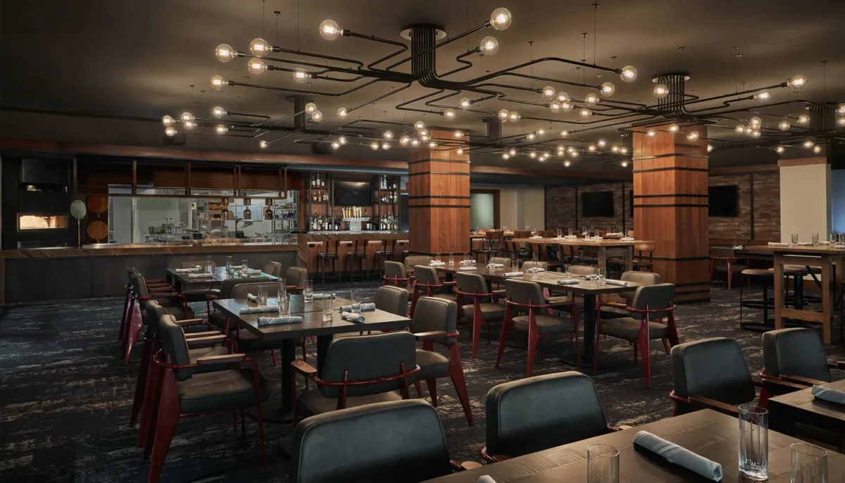 Rustic restaurant interior at Montage Big Sky, a Montana wedding venue, with exposed lightbulbs and dark wood.