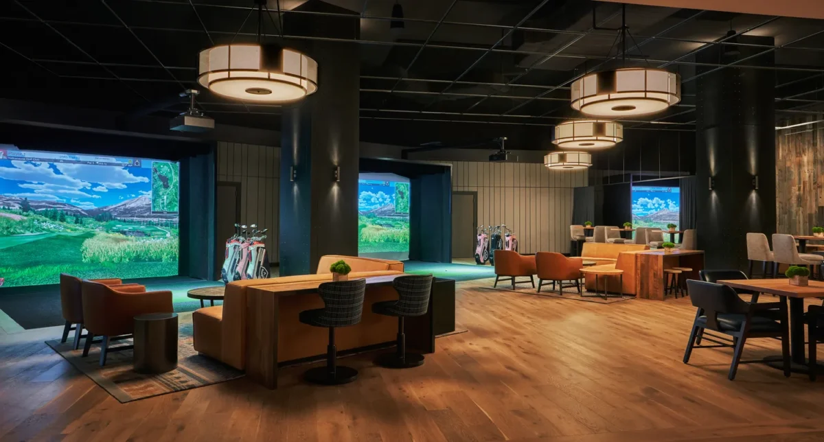 Golf simulator venue with seating and screens, perfect for a Montana wedding venue.
