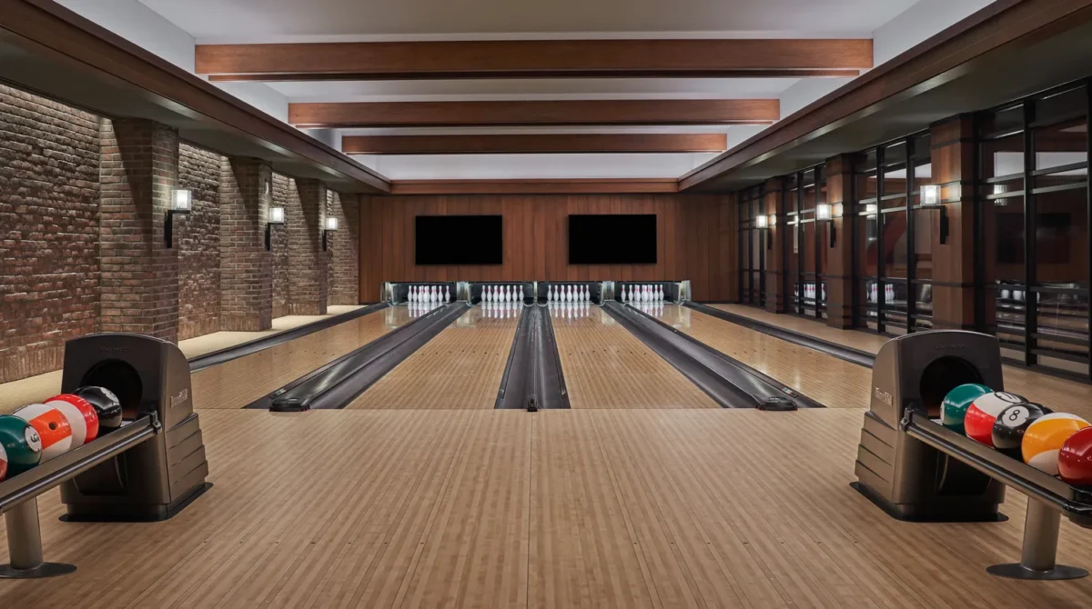 Upscale bowling alley with multiple lanes and ball return machines.
