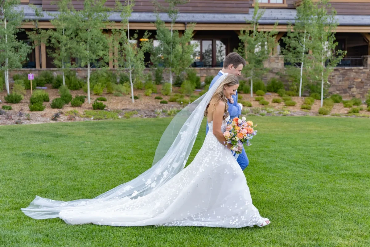 Bride and groom walking on grass at Montage Big Sky, a Montana wedding venue.