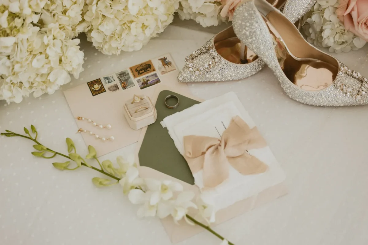 Elegant Montana wedding details: bridal shoes, invitation suite, and rings.