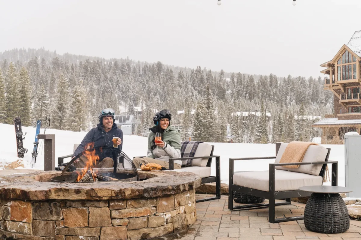 Couple enjoying drinks by a fire pit at a Montana wedding venue.