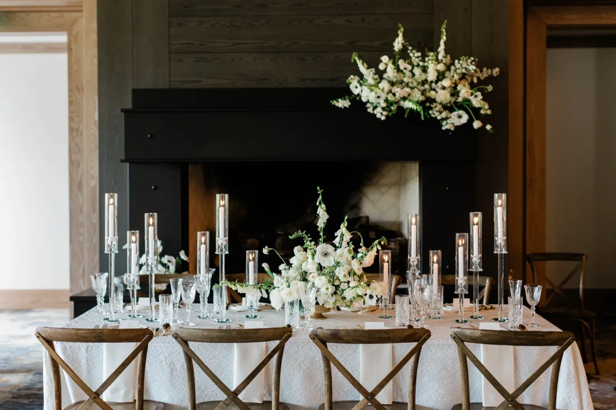 Elegant table setting with white floral arrangements and candles for a Montana wedding venue.