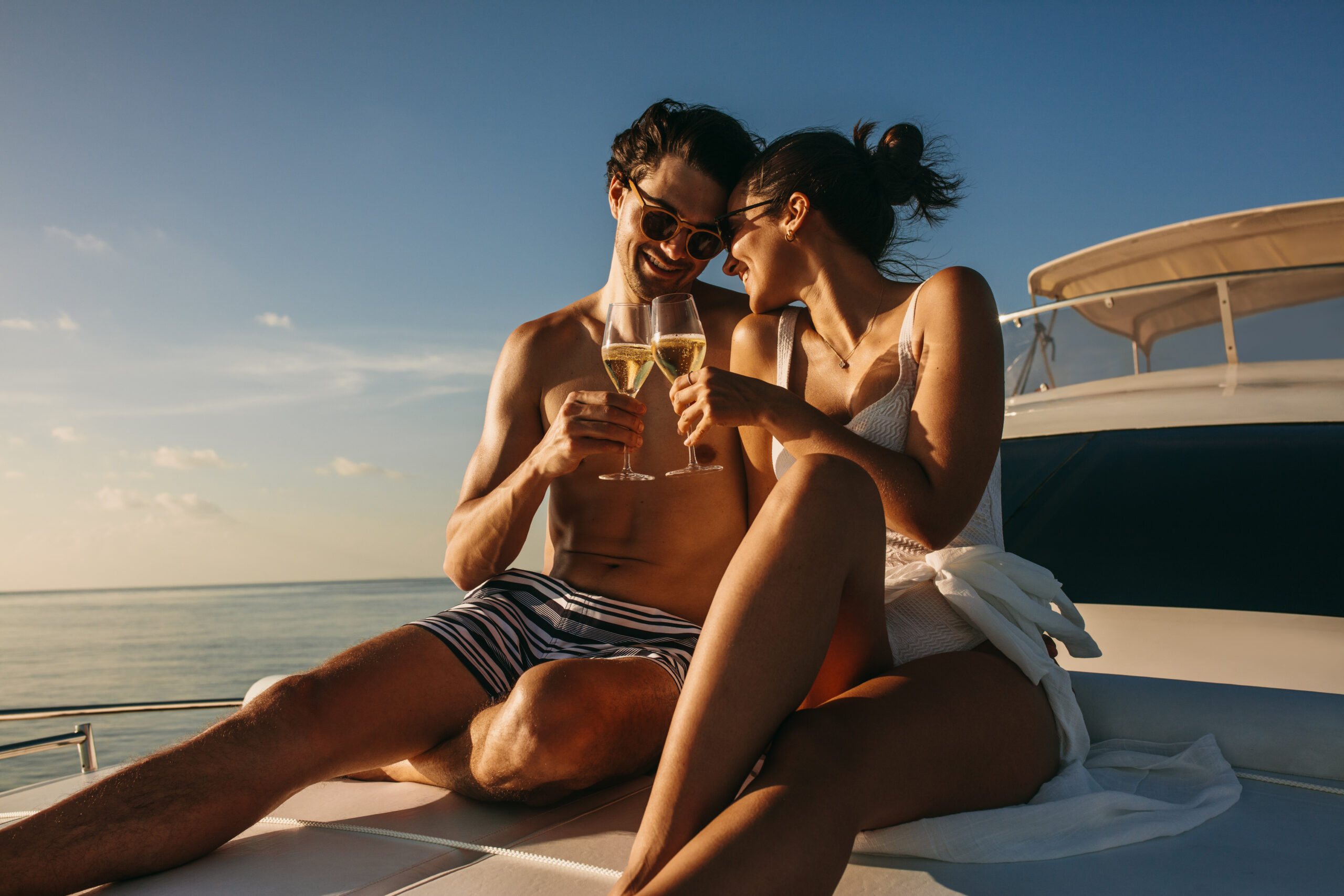 Couple toasting champagne on a yacht during their luxury honeymoon 2026.