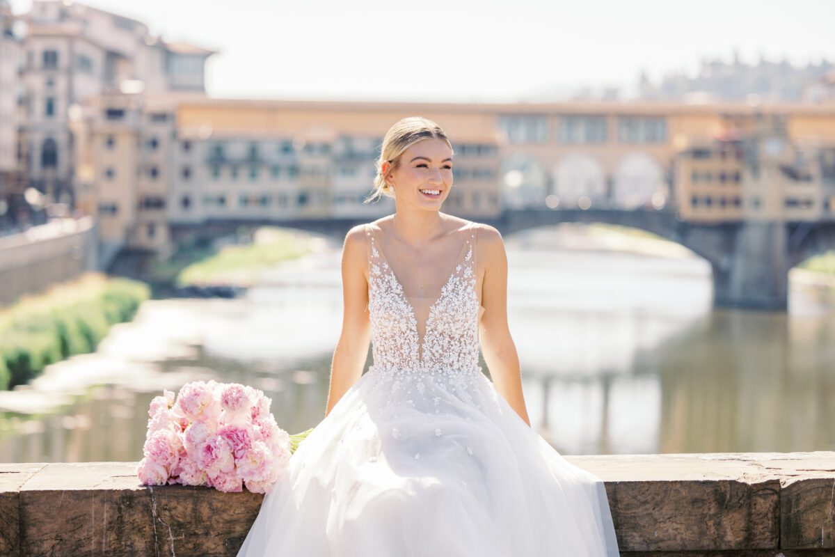 Bride in Florence with peonies, Ponte Vecchio backdrop.