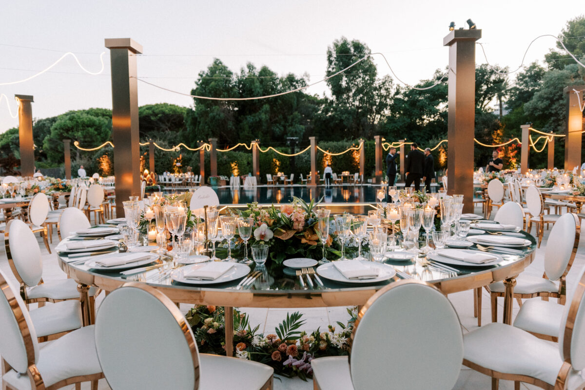 Luxury wedding reception at COMO Le Beauvallon, Saint-Tropez. Round tables with floral centerpieces and elegant white chairs.